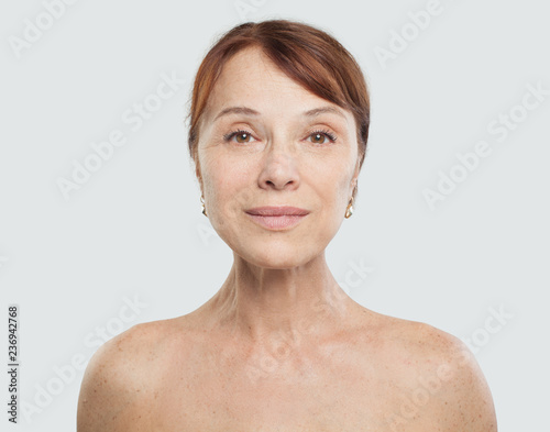 Mid adult woman face on white background. Facial treatment  aesthetic medicine and plastic surgery