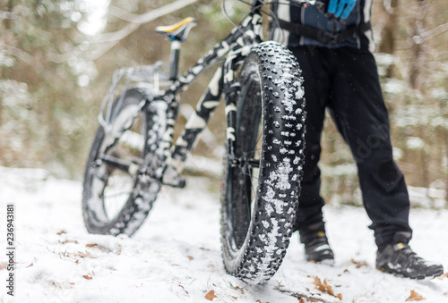 The guy keeps fatbike in the woods in winter photo