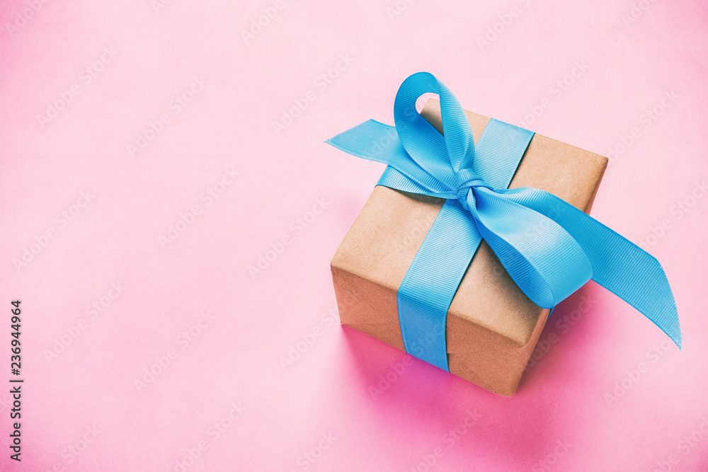 gift wrapped and decorated with blue bow on pink background vintage, toned with copy space. Flat lay, top view gift wrapped and decorated with blue bow on pink background vintage, toned with copy space. Flat lay, top view