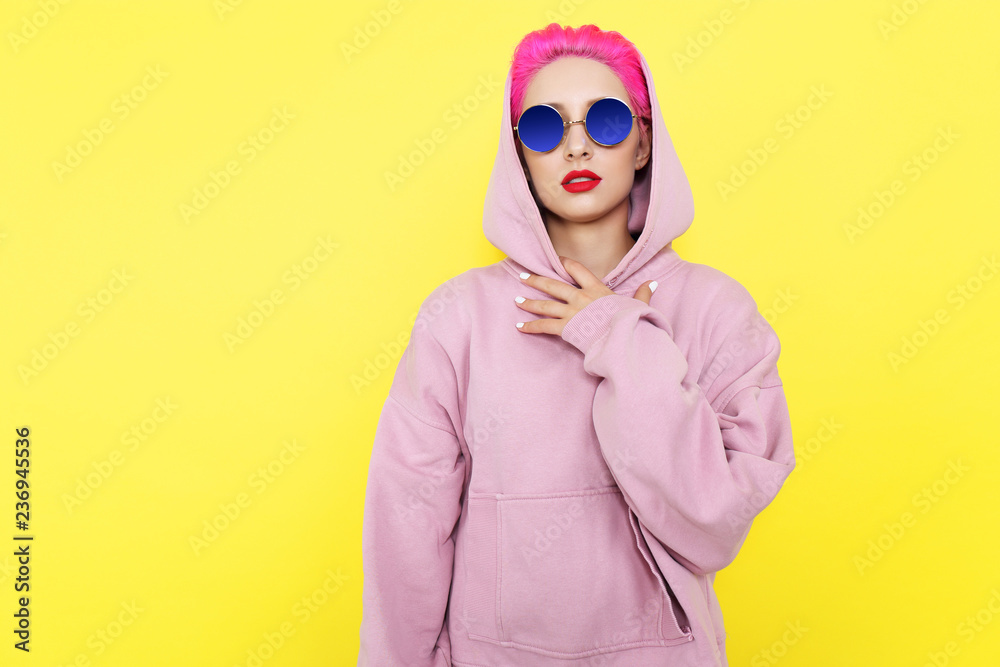 Fashion portrait of young hipster woman in pink hoody. Short pink hair Fashion portrait of young hipster woman in pink hoody. Short pink hair