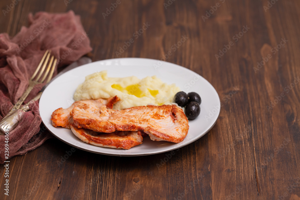 fried turkey with mashed potato and olives on white dish fried turkey with mashed potato and olives on white dish