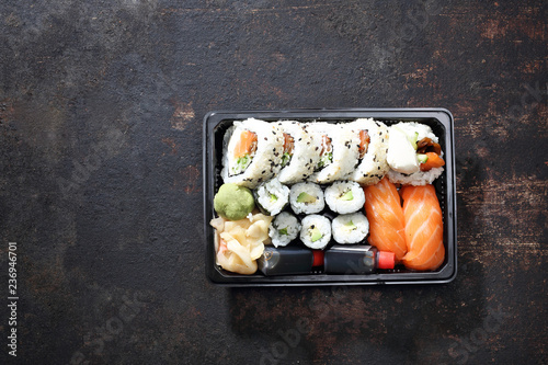 Hosomaki, futomaki i nigiri zestaw sushi. Tacka z kawałkami sushi , imbirem , wasabi i sosem sojowym na ciemnym tle.