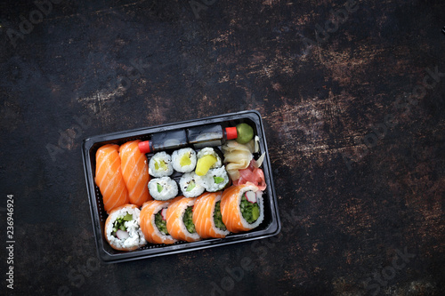 Sushi. Tacka z kawałkami sushi , imbirem , wasabi i sosem sojowym na ciemnym tle.