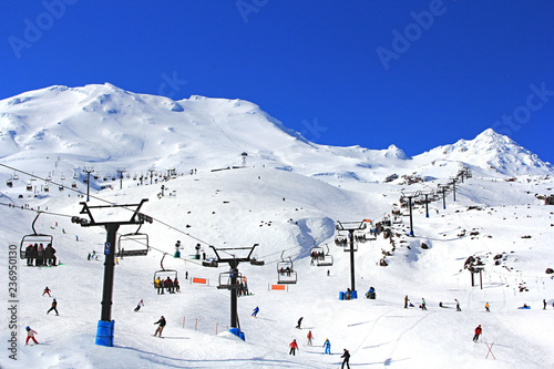 Many tourists using the cablecar for skiing , snowboarding on the beautiful winter snow Mountain Ruapehu in the Northern island of New Zealand on a bright sunny day.