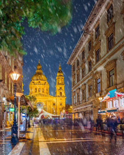Photography Budapest, Hungary - Snowy night at a Christmas market and shopping street with festive decoration, street-lamp and St