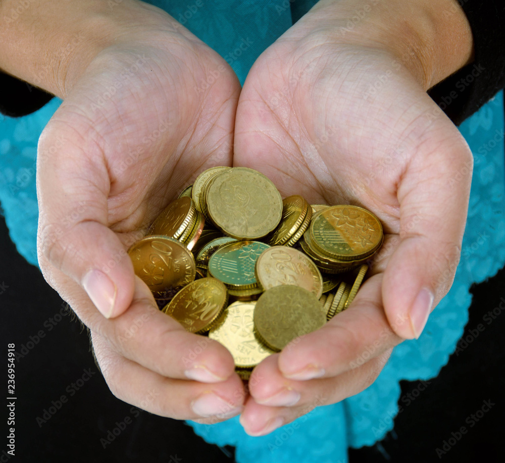 A female hand holding money against a white background A female hand holding money against a white background