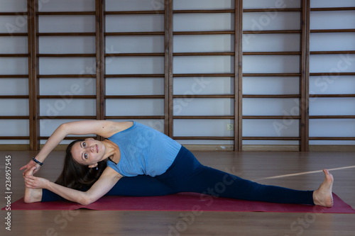 Young awesome happy woman developing flexibility. full length photo.yoga practise