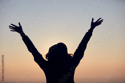 Woman with arms wide open enjoying the sunrise / sunset time. #236957716