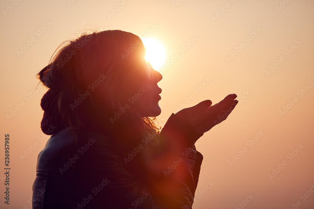 Naklejka premium Woman with praying arms enjoying the sunrise / sunset time.