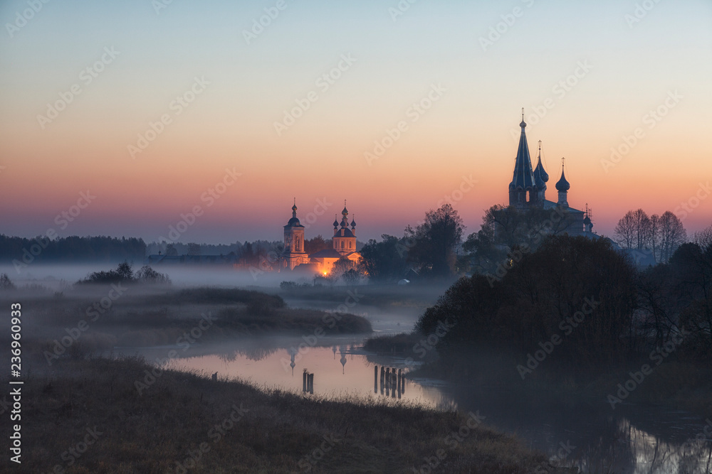 old churches  at fog sunrise in Dunilovo, Russia