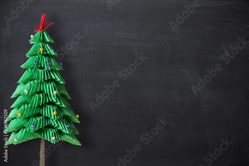 Christmas holiday empty background as copy space with origami handmade Christmas tree isolated on the left