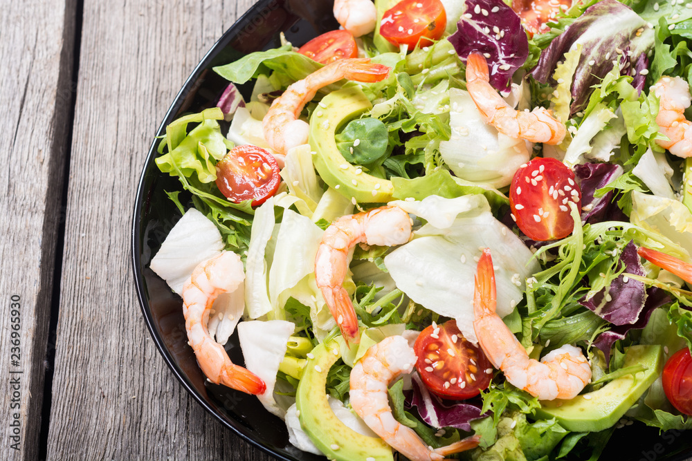 Mix of salad with shrimps , avocado and cherry tomatoes . Healthy food background Mix of salad with shrimps , avocado and cherry tomatoes . Healthy food background