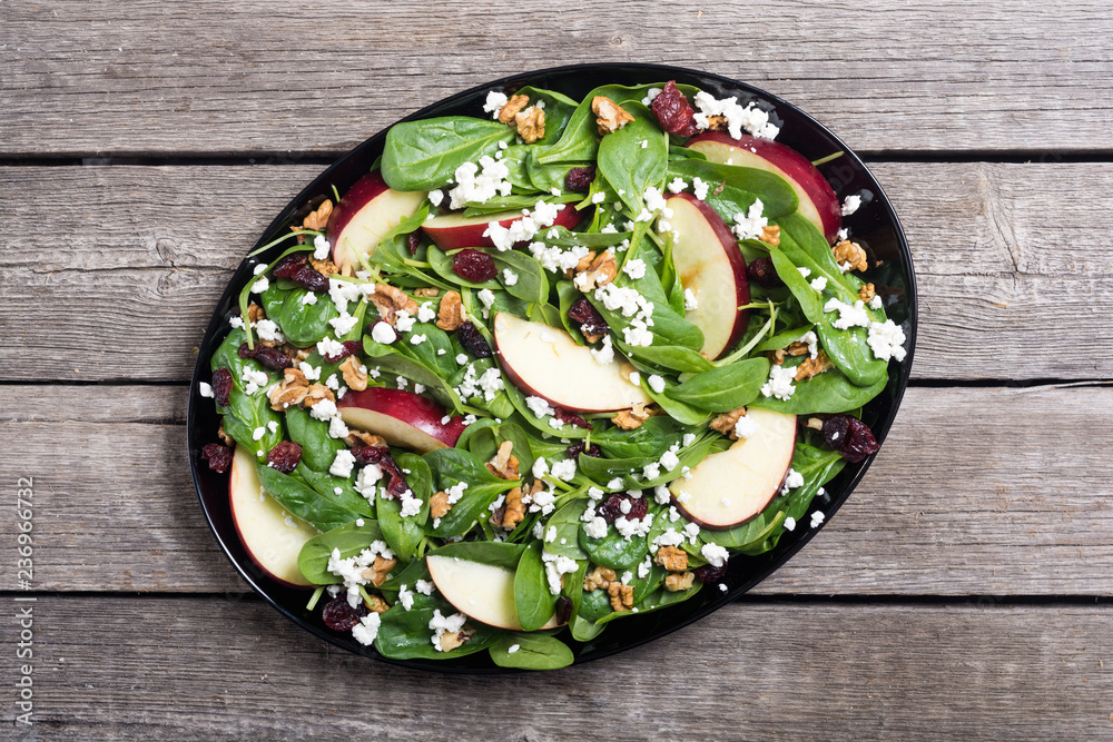 Autumn spinach salad with apple , cheese , walnut and dried cranberry . Healthy vegetarian food Autumn spinach salad with apple , cheese , walnut and dried cranberry . Healthy vegetarian food