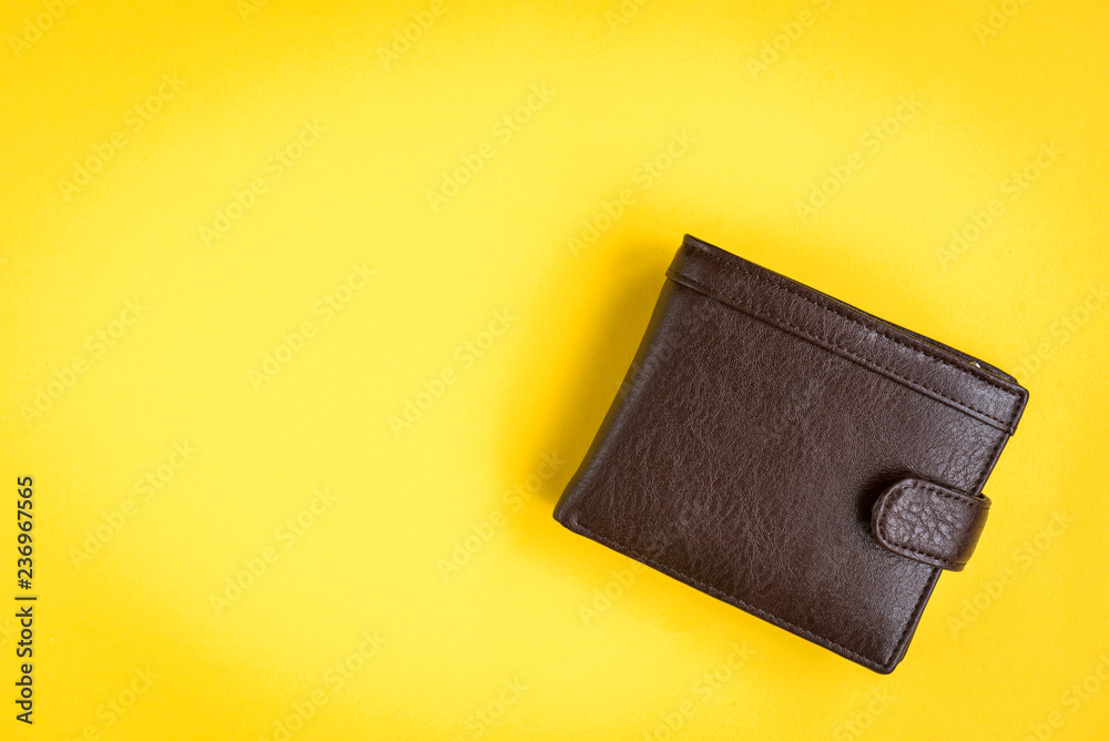 Brown men's wallet on yellow background. - obrazy, fototapety, plakaty 