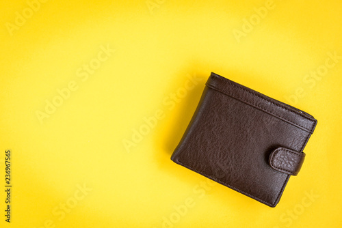 Brown men's wallet on yellow background. photo