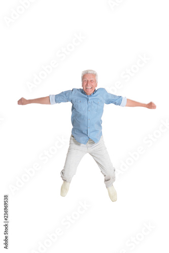 Portrait of senior man jumping on white background