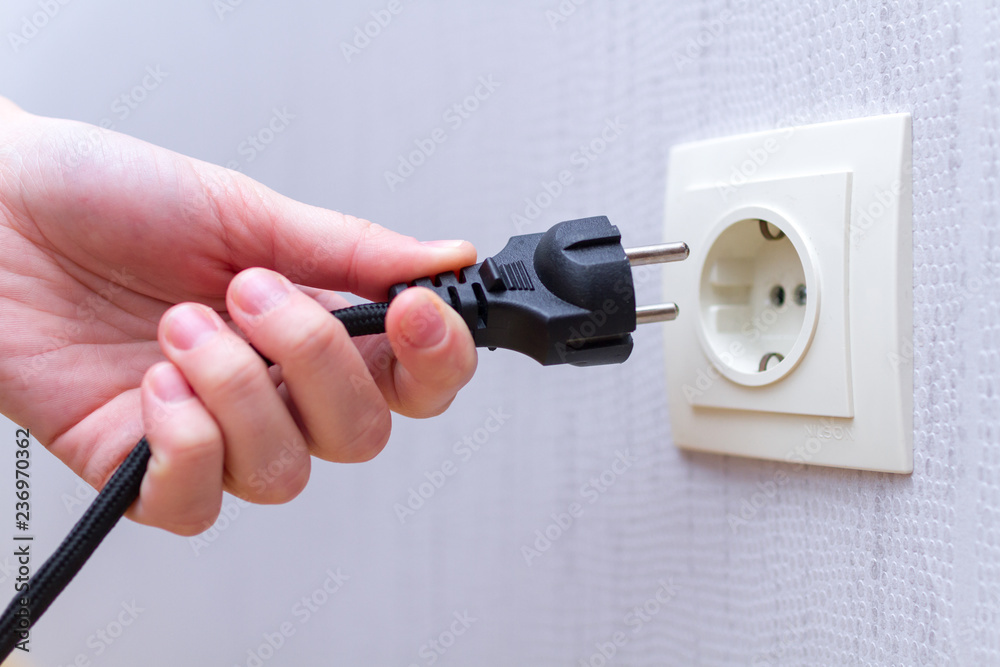 Foto Stock Ready to connect. Plugging electrical, black plug in electric  socket on wall. | Adobe Stock