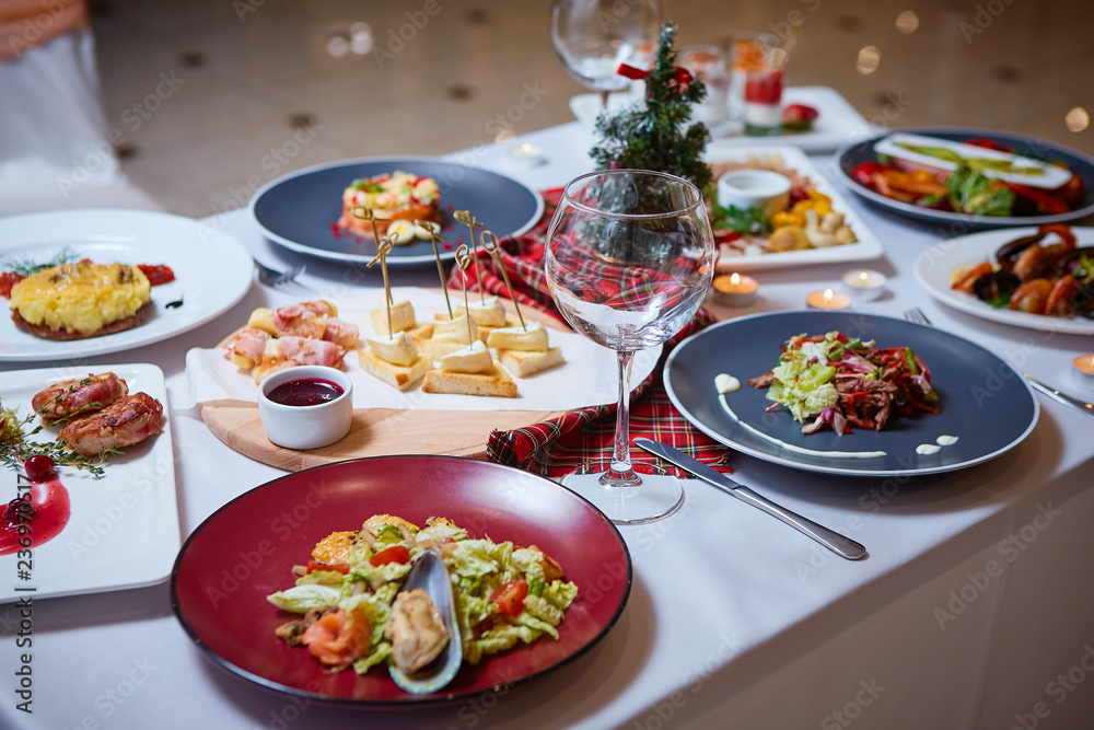 Romantic dinner setup or Holiday table setting. Many varied delicacies. Festive mood
