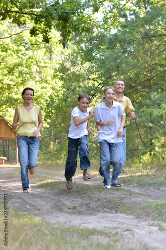Portrait of happy family of four in autumn park running