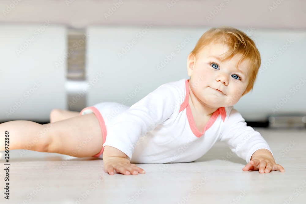 Little cute baby girl learning to crawl. Healthy child crawling in kids room. Smiling happy healthy toddler girl. Cute toddler discovering home and learning different skills Little cute baby girl learning to crawl. Healthy child crawling in kids room. Smiling happy healthy toddler girl. Cute toddler discovering home and learning different skills