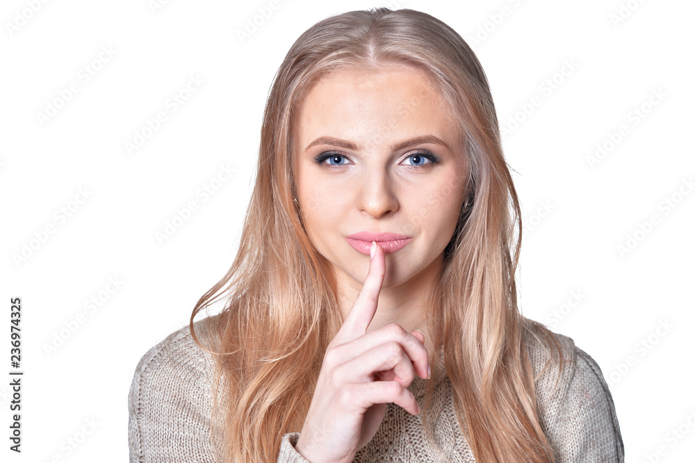 Portrait of young woman with silence gesture on white background Portrait of young woman with silence gesture on white background