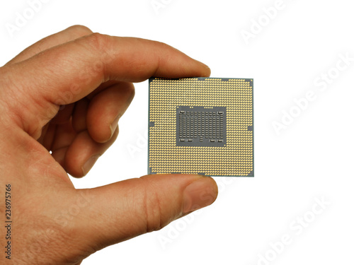 fingers hold the processor from the computer on a white background