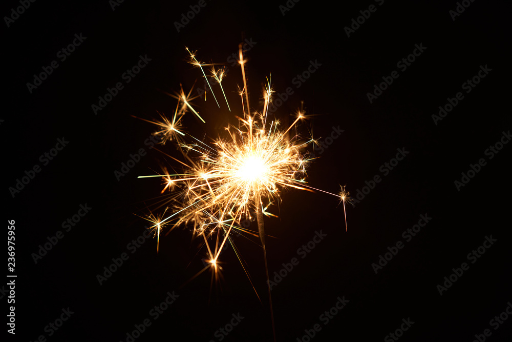 A burning sparkler on a black background isolated