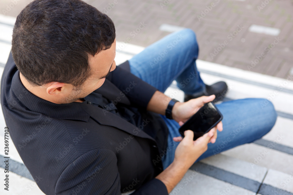 man sitting with mobile phone