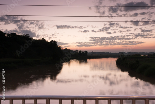 View on the bridge over the river at sunset.