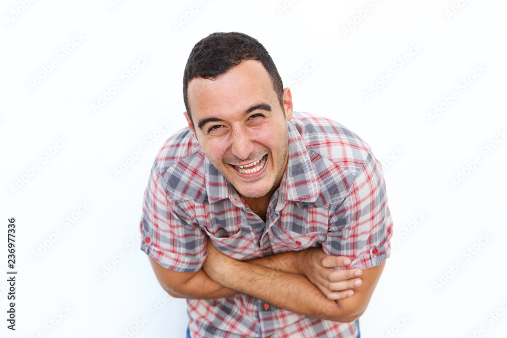 Close up happy man laughing with arms crossed against isolated white background Close up happy man laughing with arms crossed against isolated white background