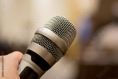 Hands holding microphones for speaking in seminar room