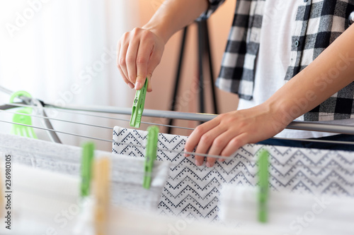 Woman hanging wet clothes with clothespins photo