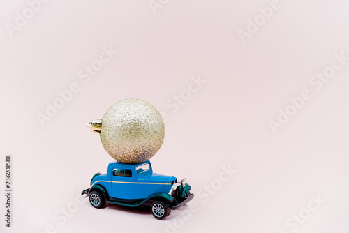 A toy car with christmass ball. Golden ball dark blue car horizontal picture.