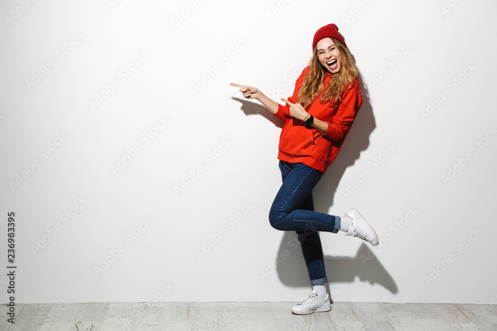 Full length photo of adorable woman 20s wearing red clothes laughing while standing, isolated over white background