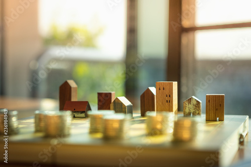 Wood house model and row of coin money on wood table, Real Estate market, Trading Estate, Mortgage Concepts