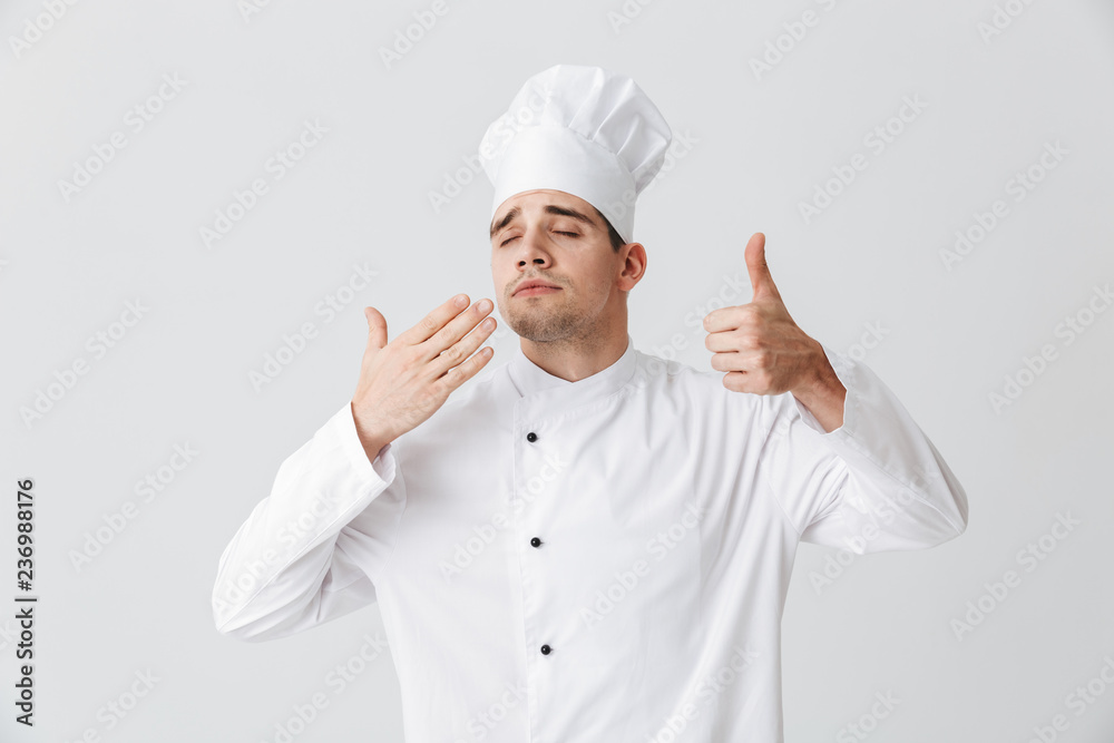 Cheerful chef cook wearing uniform tasting the smell Cheerful chef cook wearing uniform tasting the smell