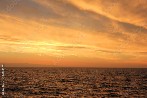 Sunset Sky Landscape Over Calm Sea Water with Vibrant Orange Cloudscape. Beautiful Sky Background at Sunset or Sunrise  Dusk and Dawn Panoramic Skyline View with Still Water on Summer Season Image