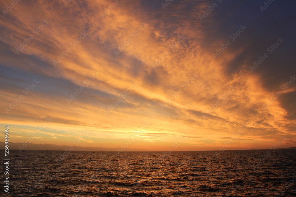 Sky Nature View of Sunset Over Calm Sea Water with Light Soft Cloudscape. Beautiful Sky Background at Sunset or Sunrise, Dusk or Dawn Panoramic Skyline View with Still Water on Summer Season Day