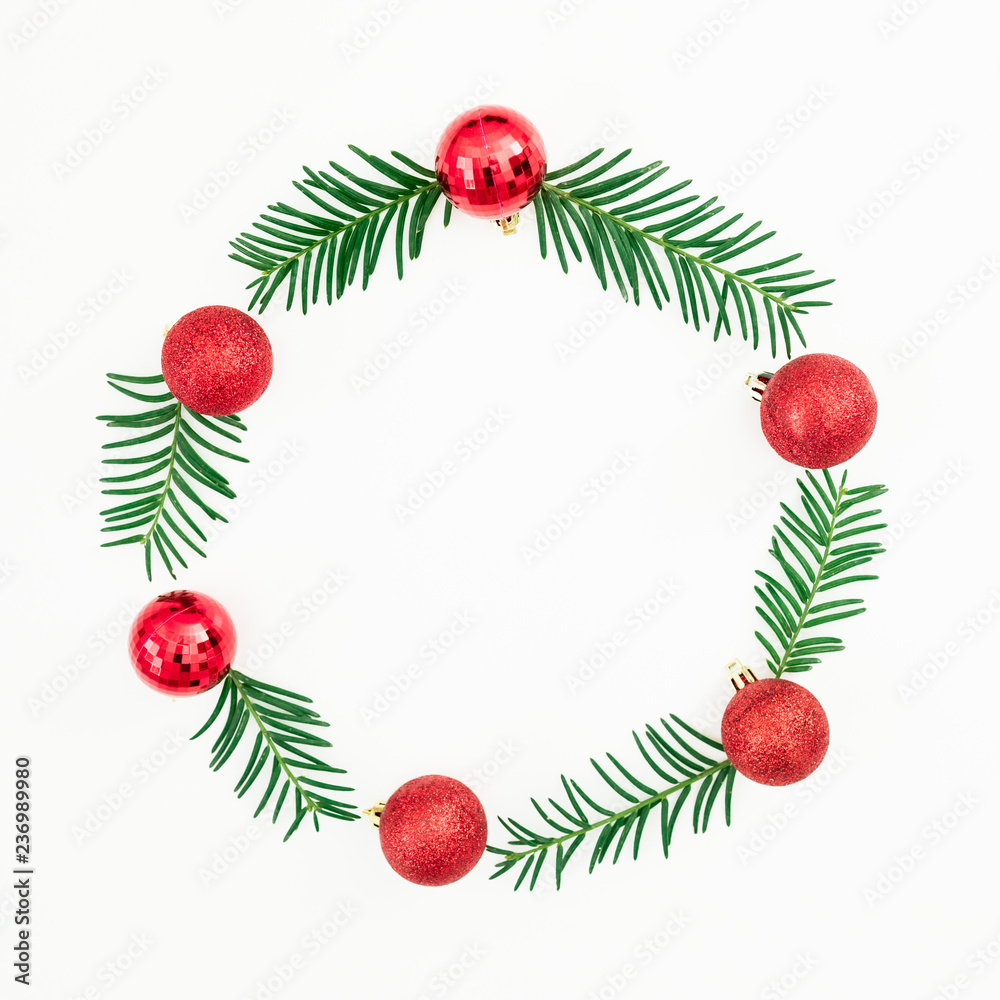 Christmas frame of fir evergreen branches and red balls on white background. Festive background. Flat lay, top view Christmas frame of fir evergreen branches and red balls on white background. Festive background. Flat lay, top view