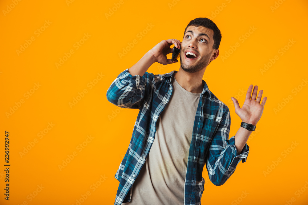 Cheerful young man wearing plaid shirt standing Cheerful young man wearing plaid shirt standing