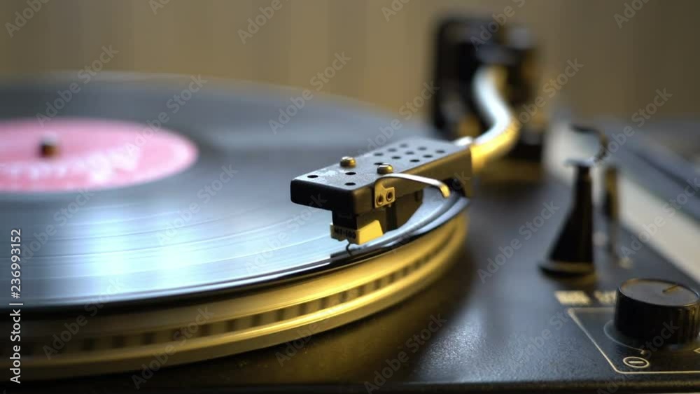 The vinyl record on DJ turntable record player close up. The rotating plate and stylus with the needle close-up The vinyl record on DJ turntable record player close up. The rotating plate and stylus with the needle close-up