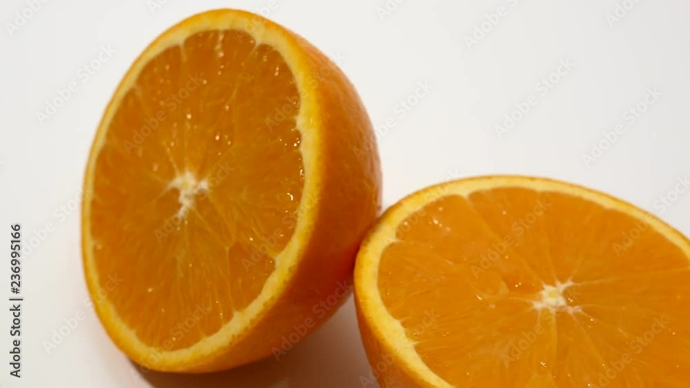 Fresh orange cut in half on white close up slider shot Fresh orange cut in half on white close up slider shot