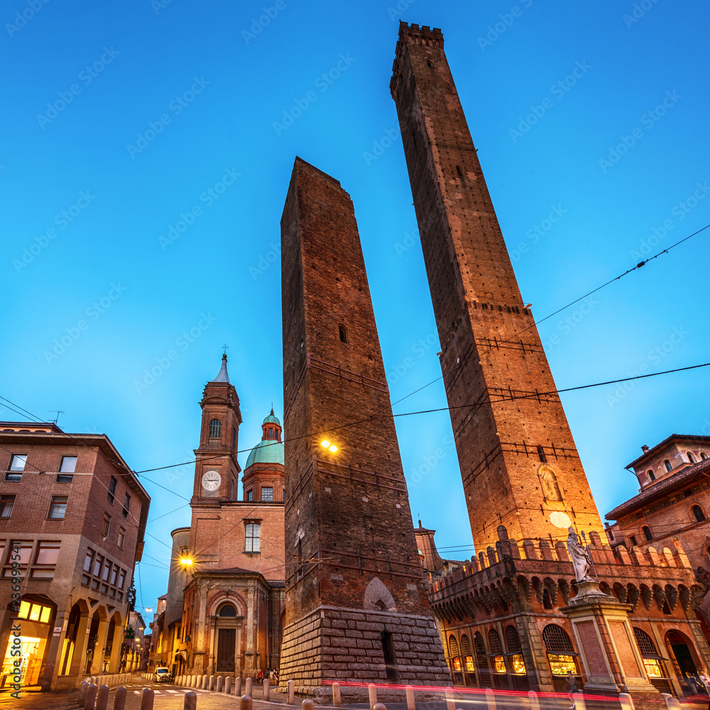 Two famous falling Bologna towers Asinelli and Garisenda. Evening view, long exposure. Bologna, Emilia-Romagna, Italy.