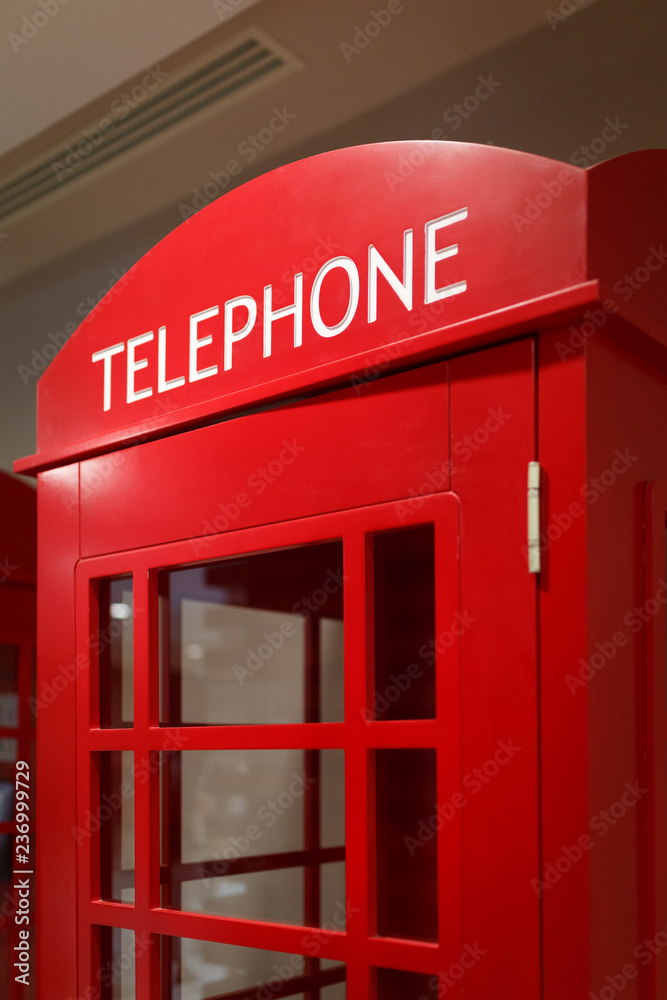 Traditional red telephone booth stands indoors as a symbol of London and the UK Traditional red telephone booth stands indoors as a symbol of London and the UK
