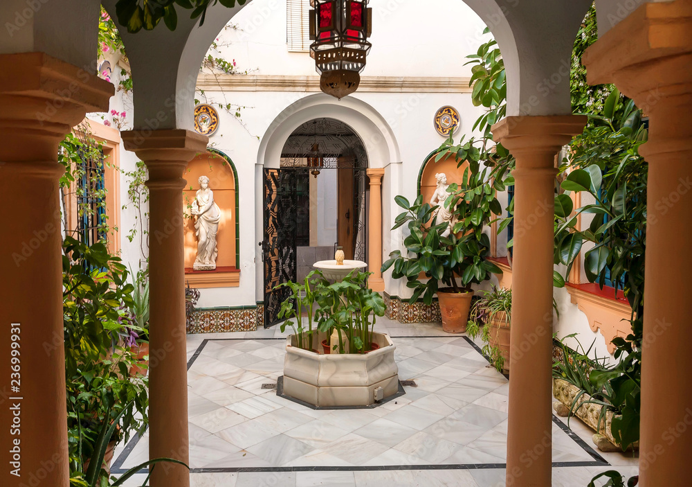 Traditional courtyard with columns, vintage sculptures and decor of Andalusia. Historical houses in Cordoba, Spain