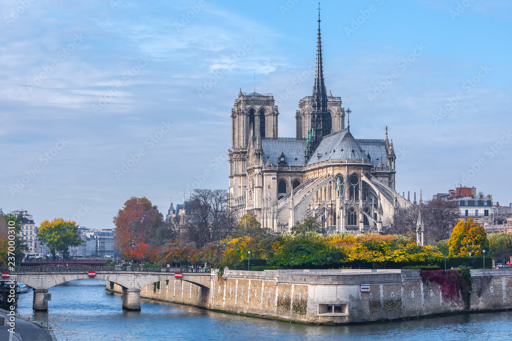 Cathedral of Notre Dame de Paris sunny autumn afternoon. Embankment of the Seine River. The natives and tourists take a walk and relax in warm weather. Blurred, unrecognizable faces. Paris. France. Cathedral of Notre Dame de Paris sunny autumn afternoon. Embankment of the Seine River. The natives and tourists take a walk and relax in warm weather. Blurred, unrecognizable faces. Paris. France.