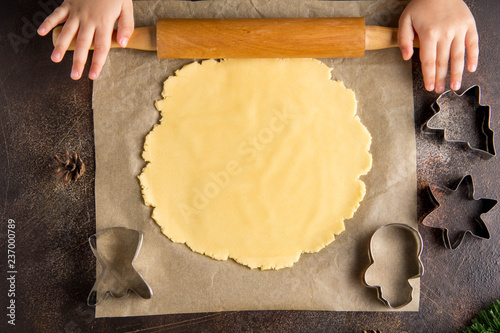Children is cooking Christmas cookies, roll out the dough, family tradition, tasty sweet holiday food photo