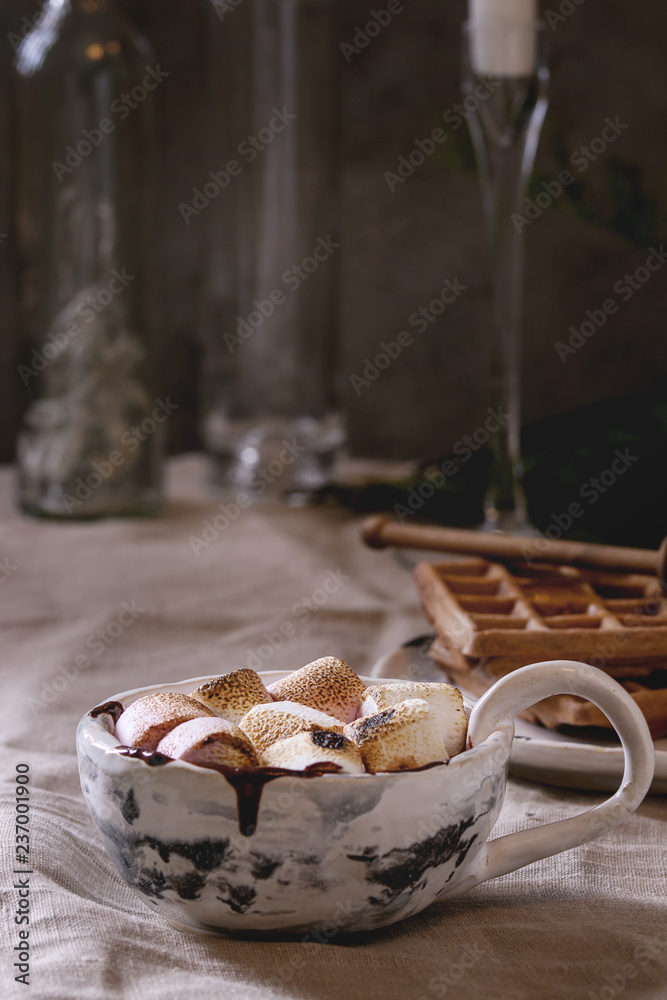 Ceramic cup of hot chocolate with marshmallow s'mores with homemade honey wafers over grey linen table cloth. Winter drink. Ceramic cup of hot chocolate with marshmallow s'mores with homemade honey wafers over grey linen table cloth. Winter drink.