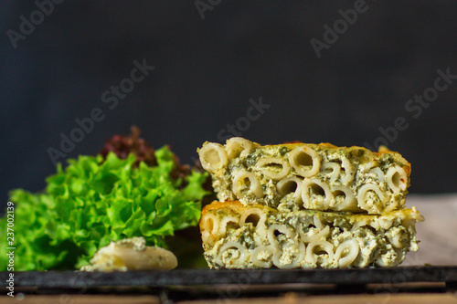 pasta casserole - penne, cheese, spinach, broccoli - main dish  (dark background). top view. copy space