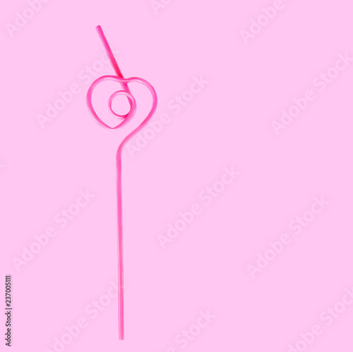 pink straw in the shape of a heart for a cocktail isolated on a pink background